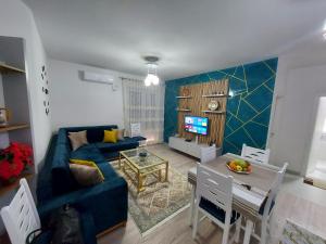 a living room with a blue couch and a table at Denis Comfort Apartment in Shkodër