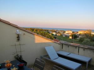 een balkon met een tafel en stoelen en de oceaan bij Duplex terrasse vue mer accès plage et piscine... in Frontignan