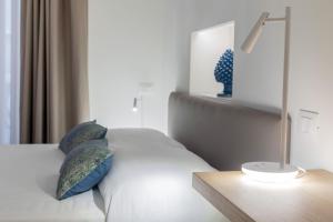 a bedroom with a bed with blue pillows and a lamp at Taormina Town - Guesthouse Sicily in Taormina