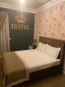 a hotel room with a bed with a crown on the wall at Hotel Egnatia in Bilisht