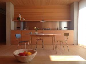 een keuken met een tafel en stoelen en een fruitschaal bij Haus am Felsen, Ferien in Vorarlberger Architektur in Bregenz