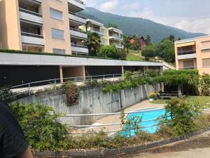 an external view of a building with a swimming pool at Condominio Andromeda Seeblick in Locarno
