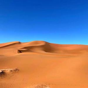 a sand dune in the middle of a desert at Nomadic Stay in Mhamid +2 photos