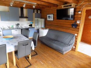 a kitchen with a table and a couch in a room at Le Chalet des Vosges in Le Tholy