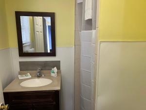 a bathroom with a sink and a mirror at Budget Inn Motel Suites Somers Point in Somers Point