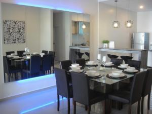 峇都丁宜的住宿－峇都丁宜檳城三葉草海灘別墅酒店，一间用餐室,配有黑色的桌子和椅子