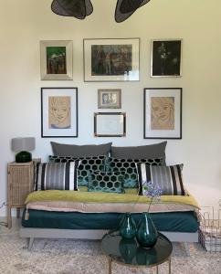 a bedroom with a bed with framed pictures on the wall at Un palmier à sa fenêtre in Grasse