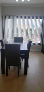 uma sala de jantar com uma mesa e cadeiras e uma janela em Plaza Temporary Apartments em Rio Grande