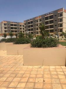 two large planters with plants in front of a building at Mo Residence SD City in Dakar