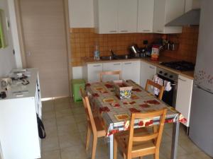 マルツァメミにあるHoliday Home Residence Azzurroのキッチン(テーブル、椅子付)、キッチン(白いキャビネット付)