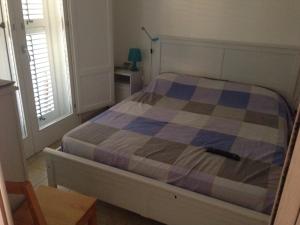 マルツァメミにあるHoliday Home Residence Azzurroのベッドルーム1室(チェック入りの毛布付きのベッド1台付)