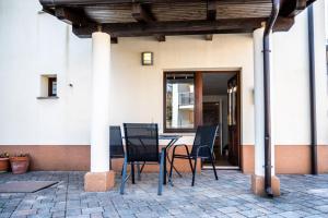 a patio with a table and chairs in front of a building at Bed & Breakfast Adelsberg Inn in Postojna