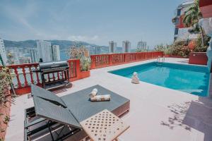 a balcony with a pool and a table and chairs at Casa con alberca con vistas a la bahia in Acapulco