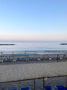 una playa con sillas azules y el océano en Luxury Tugurio, en Arma di Taggia