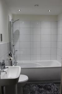 a bathroom with a tub and a toilet and a sink at Luxury Serviced Apartments in Bradford