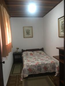een slaapkamer met een bed met een quilt bij Sitio Sao Francisco de Assis in Santo Antônio do Pinhal