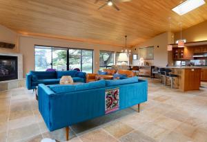 a large living room with blue couches and a kitchen at Da Yaya House in Sea Ranch