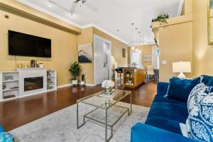 uma sala de estar com um sofá azul e uma televisão em Old East Hill Townhouse em Pensacola