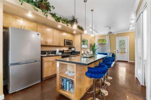 a kitchen with a refrigerator and blue bar stools at Old East Hill Townhouse in Pensacola