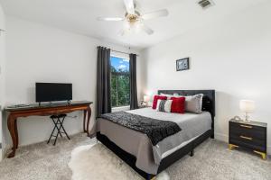 a bedroom with a bed and a desk with a computer at Old East Hill Townhouse in Pensacola