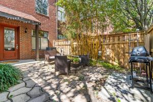 a patio with chairs and a fence and a grill at Old East Hill Townhouse in Pensacola
