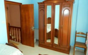 a bedroom with a wooden cabinet and a mirror at Apartamento Puerto Finisterre in Fisterra