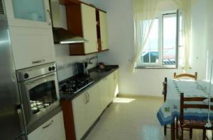 a kitchen with a stove top oven next to a table at Apartamento Puerto Finisterre in Fisterra