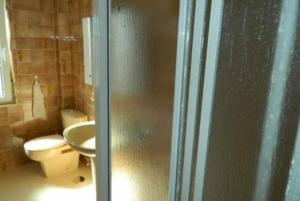 a bathroom with a shower with a toilet and a sink at Apartamento Puerto Finisterre in Fisterra +3 photos