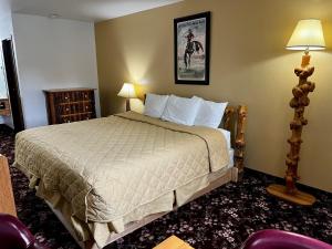 Un pat sau paturi într-o cameră la Buffalo Bill's Antlers Inn