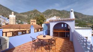 a patio with a table and chairs on a roof at Casa Bellavista Chaouen in Chefchaouene