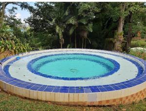 une grande piscine circulaire entourée de carrelage bleu. dans l'établissement Cabañas en el Bosque, à Borrero Ayerbe