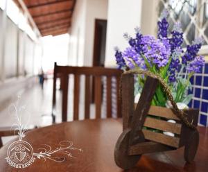 um vaso de flores roxas sentado numa mesa em Pousada Santos em Parintins