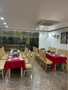 a dining room with tables and chairs with red table cloth at Thu Hoai Hotel in Cat Ba +13 photos