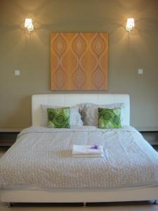 a bedroom with a large white bed with two lights at Shamrock Beach Villas Batu Ferringhi Penang in Batu Ferringhi