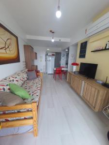Smart Residence Flat - FLAT 1009 في تيريسينا: غرفة معيشة مع أريكة وتلفزيون بشاشة مسطحة