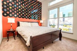 a bedroom with a bed with an orange wall at RENU at Downtown Houston in Houston