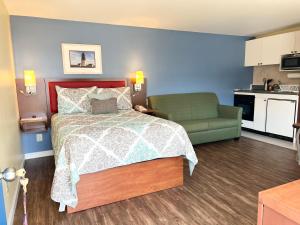 1 dormitorio con 1 cama y 1 sofá verde en Scarborough Beach Motel, en Narragansett