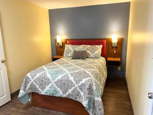 sypialnia z łóżkiem z biało-niebieską kołdrą w obiekcie Scarborough Beach Motel w mieście Narragansett