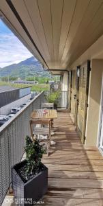 un balcón con una mesa de madera y un banco. en Charmant appartement en Saint-Gervais-les-Bains