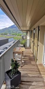 uma varanda com uma mesa de madeira e um banco. em Charmant appartement em Saint-Gervais-les-Bains