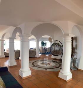 un salon avec des colonnes blanches et une chambre avec des canapés dans l'établissement Ocean Front Dream Home Getaway, à Campo del Medio