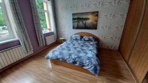 Schlafzimmer mit einem Bett mit blauer Decke in der Unterkunft Daugavpils city centre in Daugavpils
