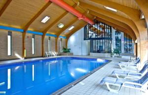 a large swimming pool with chairs and a swimming pool at The Crows Nest in Falmouth