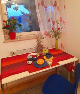 une table avec de la nourriture au-dessus d'un tissu de table rouge dans l'établissement Citynahes Wohnen am Brenzpark, à Heidenheim an der Brenz