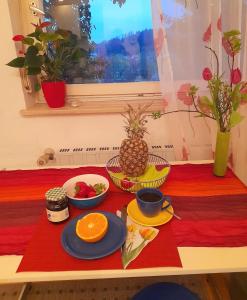 une table avec plaques alimentaires et ananas dans l'établissement Citynahes Wohnen am Brenzpark, à Heidenheim an der Brenz