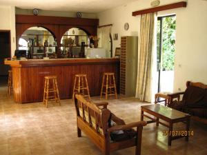 a living room with a bar with stools in it at Hotel Narkissos in Archangelos