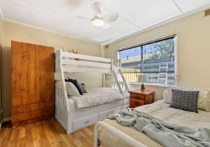 a bedroom with a white bunk bed and a window at Metung Akora 2Bdrm Apartment 1 - Pets & Boats welcome! Close to Town, Free Wifi & Netflix in Metung
