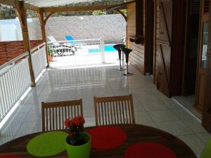 a patio with a table and chairs on a deck at Aux petits flots in Le Gosier