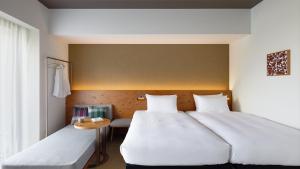 Un pat sau paturi într-o cameră la HOTEL STRATA NAHA