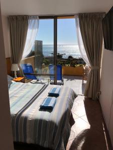 een slaapkamer met een bed en uitzicht op de oceaan bij Departamento Algarrobo in Algarrobo